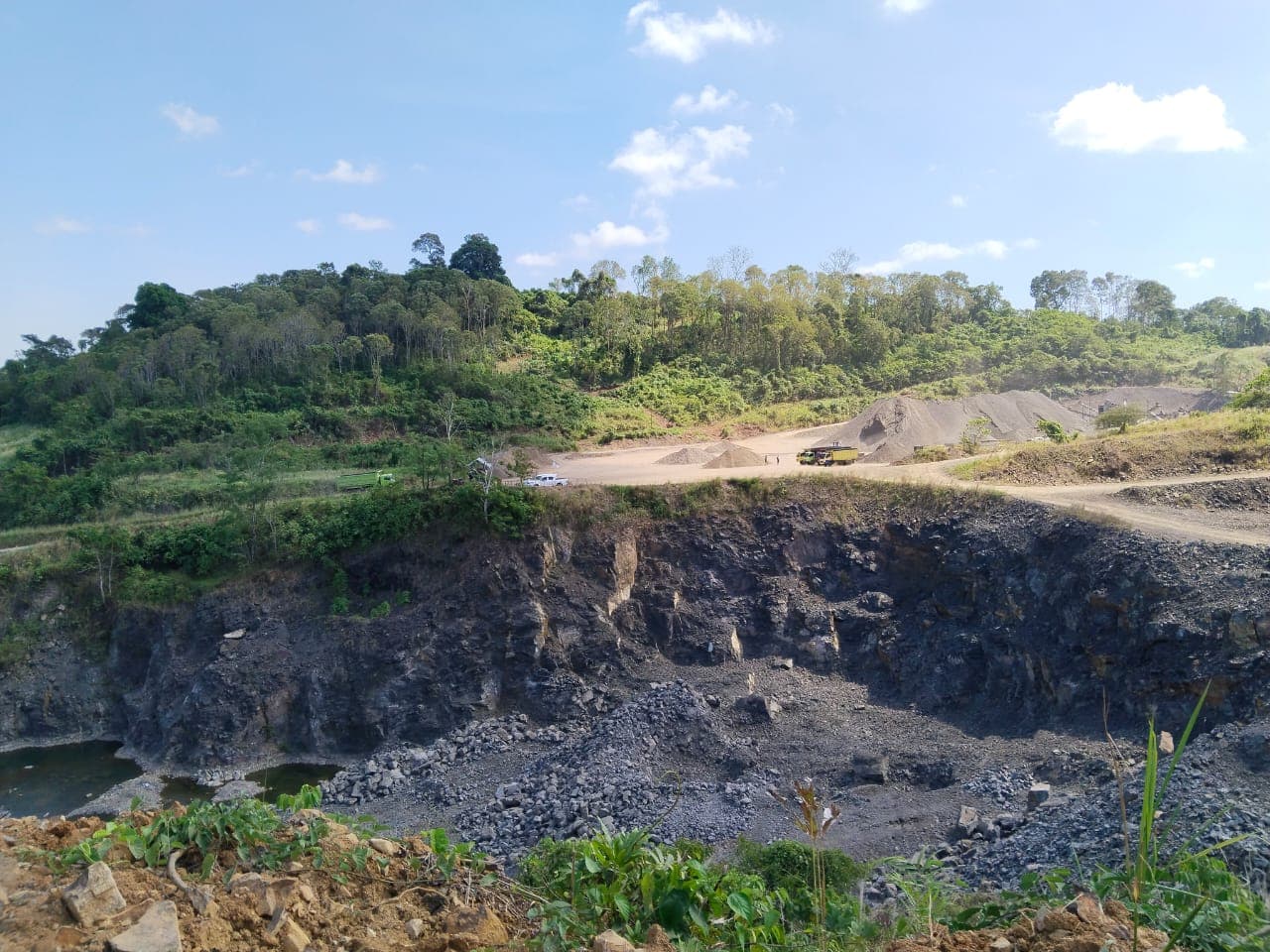 Jenjang tambang dan jalan angkut dilihat dari seberang pit.