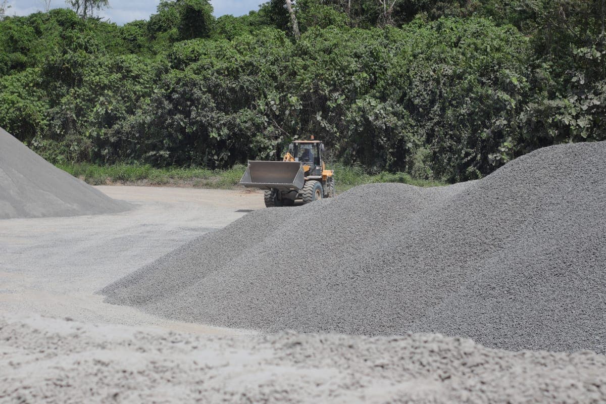 Wheel loader bekerja di samping tumpukan agregat.